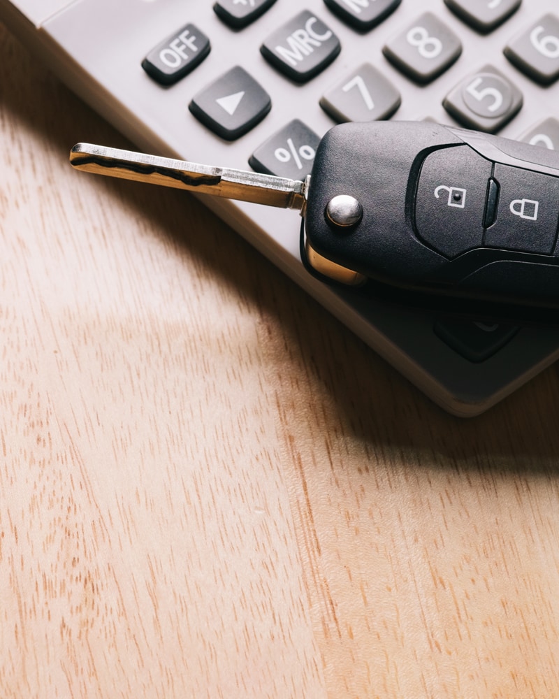 a set of car keys rests on a laptop keyboard